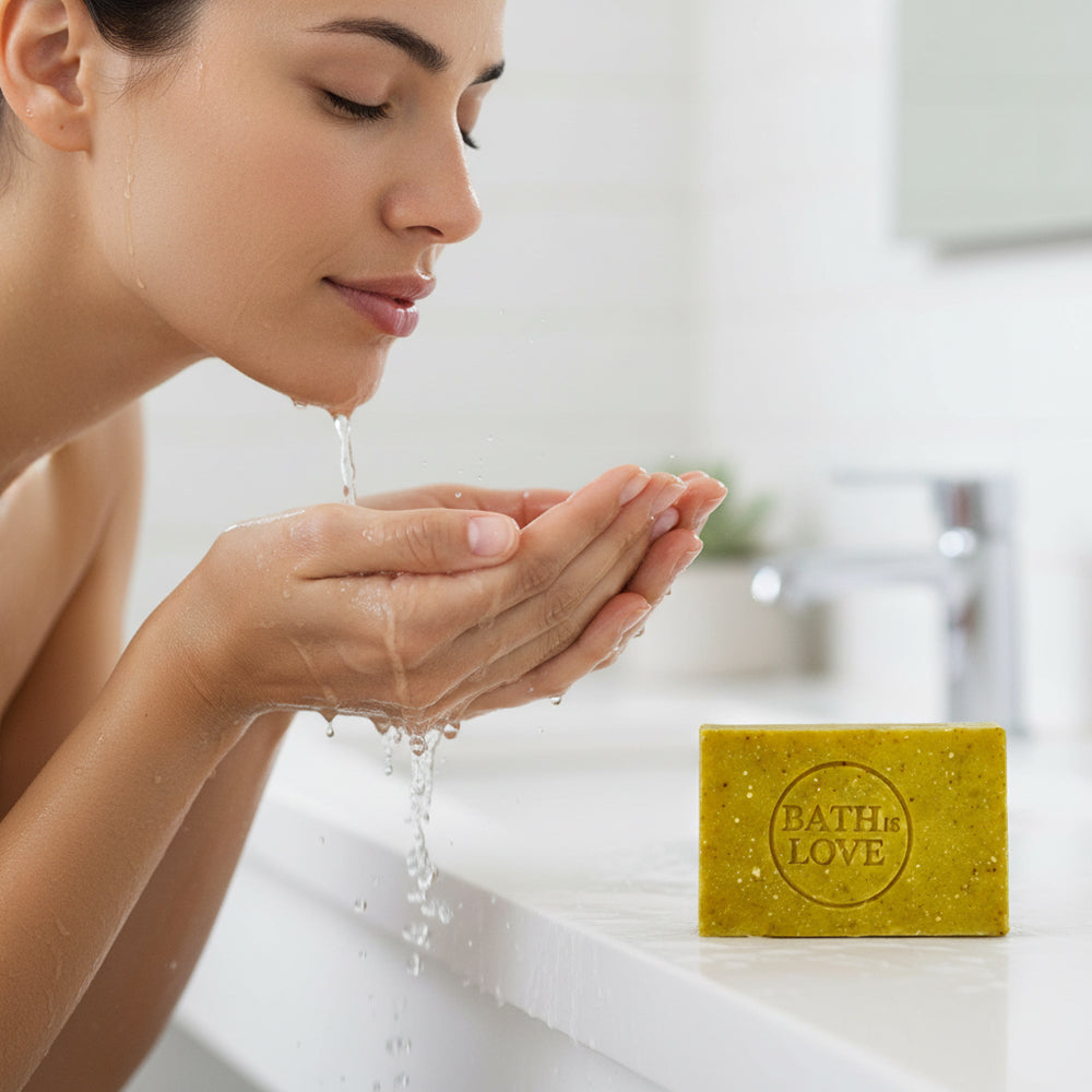 Woman washing hands with a bar of soap labeled 'Bath in Love' in the foreground.