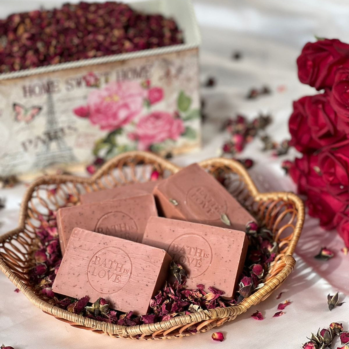 Pink soap bars with 'Path of Love' branding in a wicker basket with dried flowers and roses.